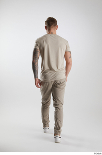 Gilbert 1 back view dressed grey t-shirt grey trousers walking…